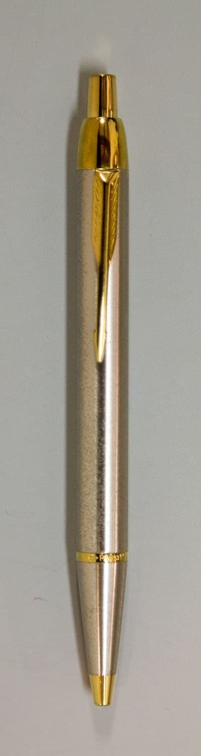 Bolígrafo plateado y dorado de la marca Parker.
